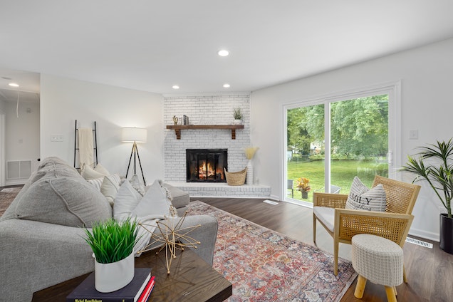 living room with white brick fire place and a grey couch